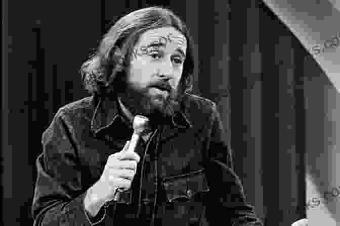 A Black And White Photo Of George Carlin Performing Stand Up Comedy In The 1970s, With A Cigarette In His Hand And A Mischievous Expression On His Face. The Punk Turn In Comedy: Masks Of Anarchy (Palgrave Studies In Comedy)